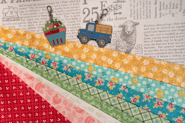 Colorful fabric strips in various patterns, alongside a truck and a flower basket ornament on a text background.