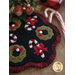 A decorative black fabric mat featuring green and red Christmas wreaths, candy canes, and small red bows, with a scalloped edge.