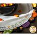 A round, decorative table mat featuring a black bowl filled with candy corn, surrounded by playful fabric shapes in Halloween-themed colors. The mat has the embroidered text Trick or Treat * Smell my feet * Give me something good to eat around the edge.