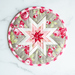 Grey and red floral folded star hot pad on a white background