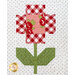 A quilted design featuring a flower with a checkered red and white pattern for the petals, a central floral motif, and green leaves on a white background with polka dots.