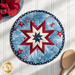 Light blue patriotic Folded Star Hot Pad laid flat on a wood table