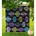 The beautiful Simplify Quilt made with Serenity Lake fabrics hung outdoors