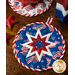 The coordinating white and blue America the Beautiful Folded Star Hot Pad on a wood table