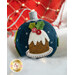 A decorative felt ornament in the shape of a round blue ball. It features an illustration of a chocolate cake with white icing on a plate, adorned with red berries and green leaves, with white snowflakes surrounding it. The background includes soft white material.