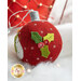 A red felt Christmas ornament featuring a snowman with a green scarf and holly leaves adorned with red berries. The background is soft and snowy with twinkling lights.