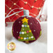 A handmade maroon Christmas ornament featuring a decorative tree design with colorful buttons and a yellow star on top, set against a snowy background.