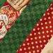 A close-up of a patchwork fabric featuring various Christmas-themed patterns, including green and red stripes, polka dots, and vintage holiday labels.