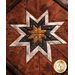 Brown, white, black and tan fabric layered to make a center star in the Folded Star Hot Pad