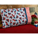 A patriotic pillowcase featuring classic gingham and vintage trucks propped up against a wood wall 