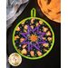 Round hot pad with central folded star design featuring Halloween themed fabrics.