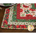 Christmas themed floral table topper on wood table.