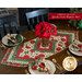 Christmas themed floral table topper on wood table next to matching cloth napkins. 