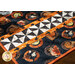 Halloween themed table runner featuring retro styled Halloween motifs and white and black pinwheel stripe.