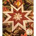 Square autumn themed floral hot pad with a central folded star design on wooden table.