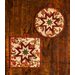 Two autumn themed floral hot pads with a central folded star design on wooden table.