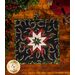 Square hot pad made of black fabric with tossed horseshoes and holly featuring a central folded star.