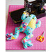 An adorable stuffed sewn frog next to a sewing machine and scissors
