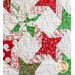 Christmas quilt featuring green and red stars on white background.