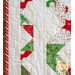 Christmas quilt featuring green and red stars on white background.