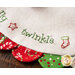 White Scalloped Table Topper with red and green scallops featuring Christmas themed embroidery of the word 