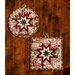 Two cream hot pads featuring holiday phrases and central folded star design on wood table.