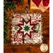 Square cream hot pad featuring holiday phrases and central folded star design on wood table.