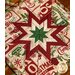 Square cream hot pad featuring holiday phrases and central folded star design on wood table.