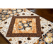 Table runner with central diamond design and angled strips the ends made of coffee themed fabrics in neutral colors.