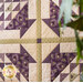 Wall hanging made with Geometric designs in purple and cream floral fabrics.