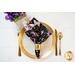 Reversible cloth napkin one side features black fabric with purple butterflies, the other side features white fabric with purple florals.