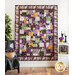 Quilt with patchwork design made of purple, yellow, teal, and black fabrics featuring florals, fish, and butterflies.