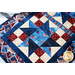 Red, white, and blue table runner made of patriotic fabric prints and geometric piecing.