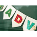 A decorative banner with fabric letters spelling ADV in various colors and patterns, hanging against a green background.