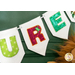 A decorative banner displaying the letters U and R in colorful, patterned fabric on white felt flags, with a green background.