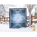 Quilt featuring flower petal shaped piecing of tonal blue batik fabric.