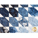 Quilt featuring flower petal shaped piecing of tonal blue batik fabric.