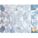 Quilt featuring flower petal shaped piecing of tonal blue batik fabric.