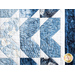 Quilt featuring flower petal shaped piecing of tonal blue batik fabric.