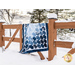 Quilt featuring flower petal shaped piecing of tonal blue batik fabric.