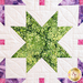 A quilt with geometric square and triangle designs made of multicolor fabrics on white.