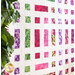 Quilt of squares and rectangles made of pink, purple, and green floral fabrics on white background.