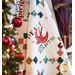 White quilt with lattice made of small squares and holiday motifs in between draped over furniture.