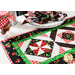 The corner of a table with a white tablecloth and table runner with a place setting and coordinating napkin.