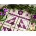 Table runner with geometric triangle and scallop design with appliqué flowers on the ends.