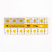 A clear acrylic quilting ruler with yellow hearts and geometric shapes, labeled with measurements in inches.