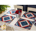 Placemats made of strips of patriotic printed red, white, and blue strips of fabric in a diamond design.