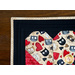 Table runner with interlocking hearts design made of illustrated cat printed fabrics and black border.