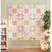 A quilt with geometric square and triangle designs made of pastel color fabrics on white.