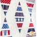 White quilt with diamonds made of strips of red white and blue patriotic fabrics.